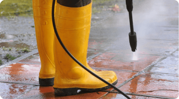 person pressure washing floor